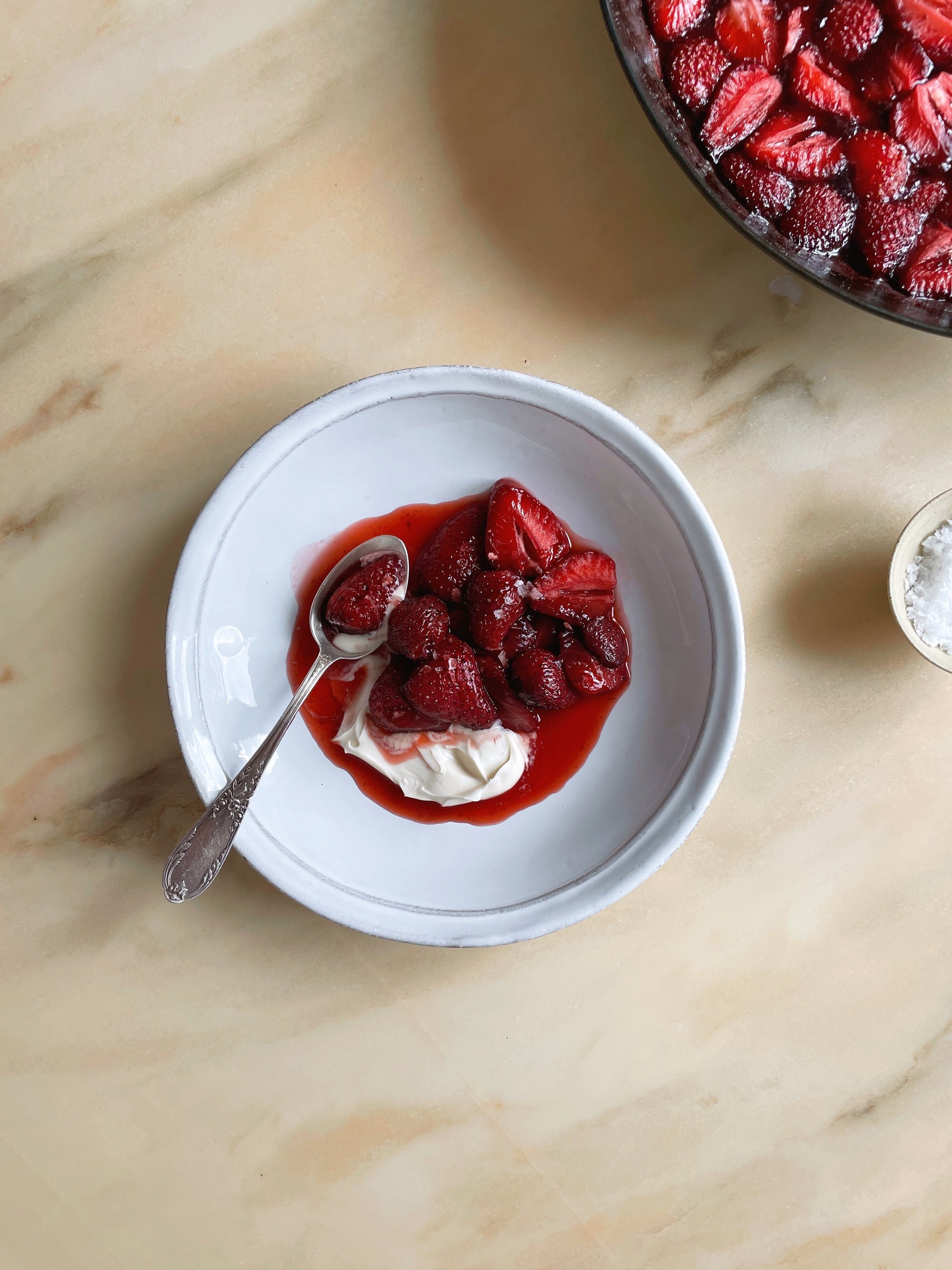 A bowl with roasted strawberries and crème fraîche.