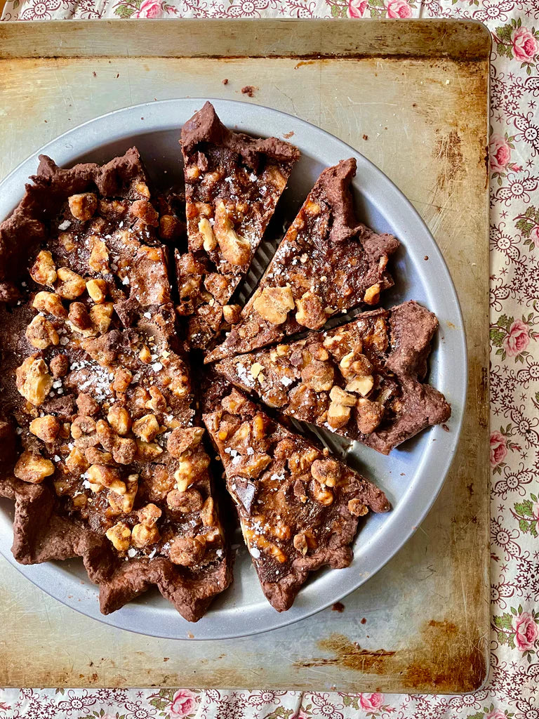 A whole walnut maple cocoa pie cut into slices.