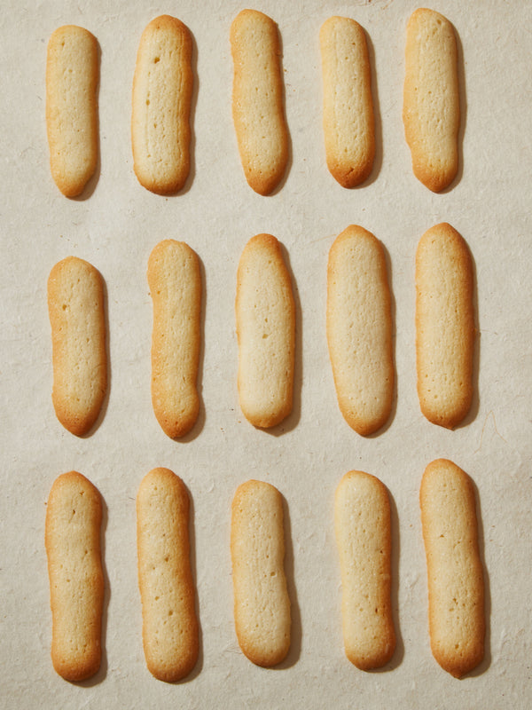 Fifteen long, tan colored cookies.