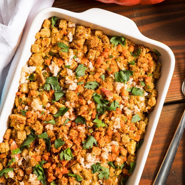 A baking dish with cooked crab stuffing, garnished with chopped parsley.