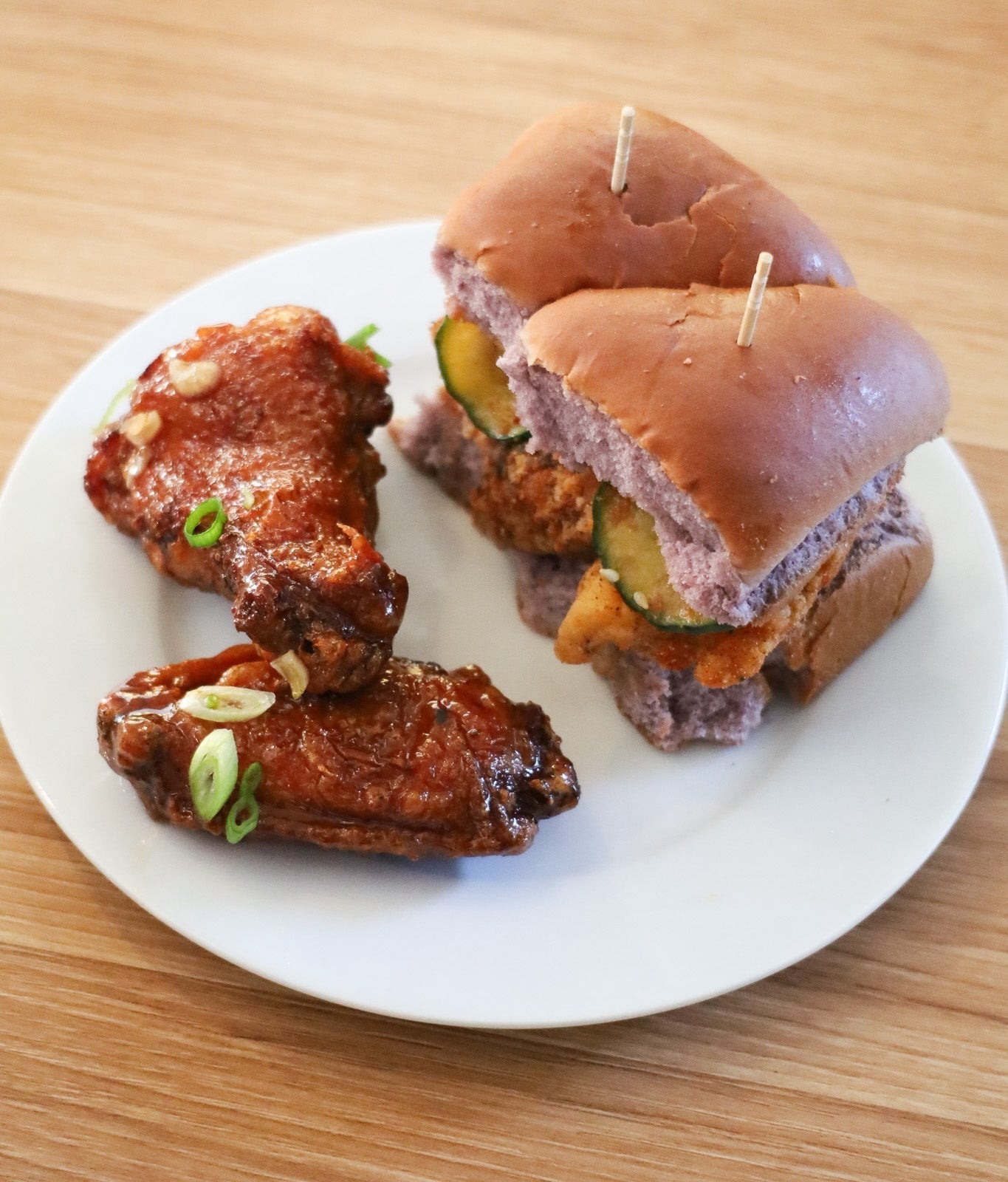 A plate with chicken sliders and chicken wings. 