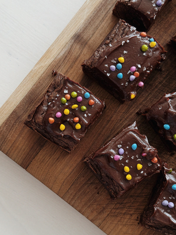 Five slices of brownies with frosting and sprinkles.