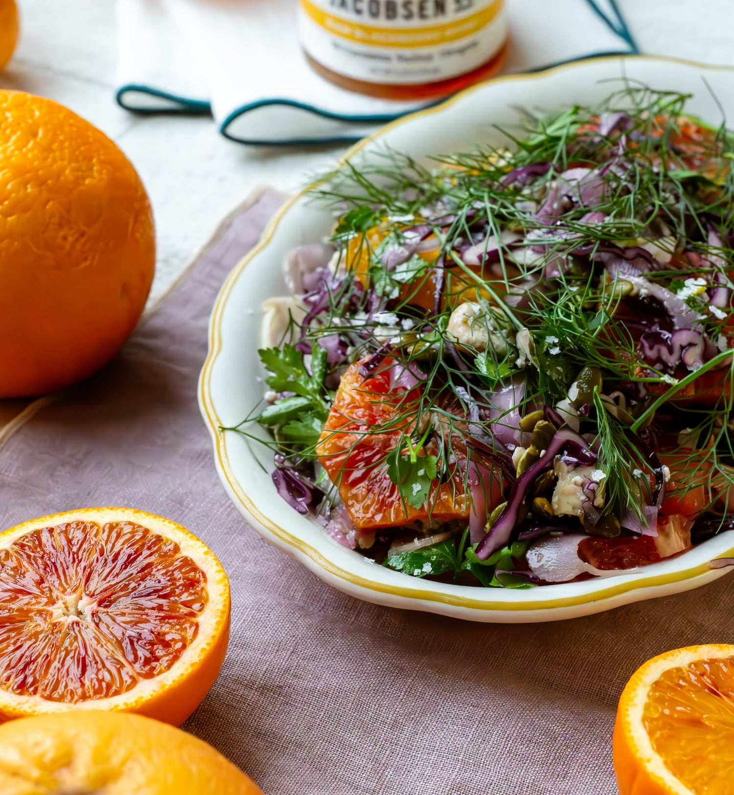 A bowl of citrus salad surrounded by oranges.