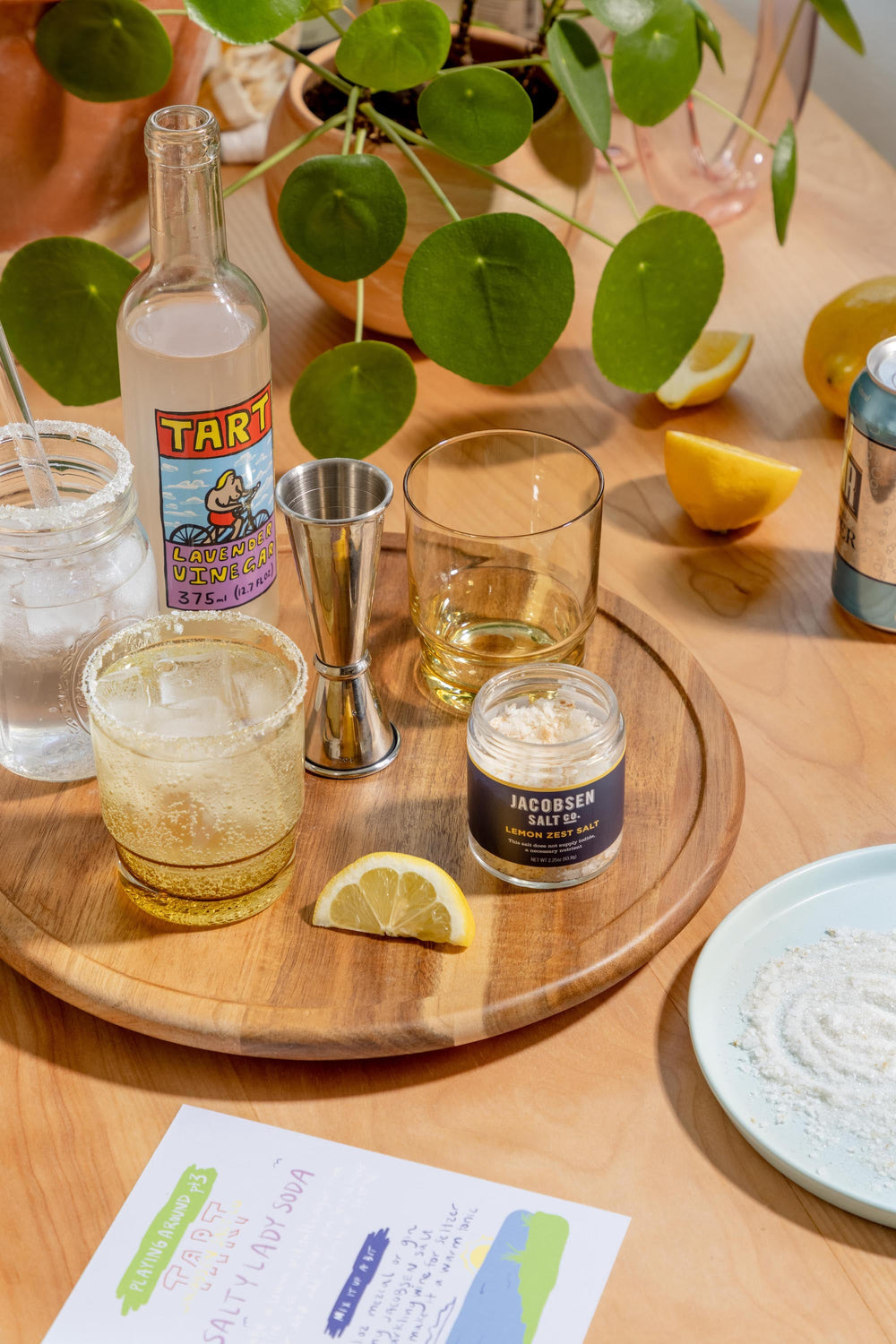 A table with vinegar, salt, and assorted glassware for making soda.