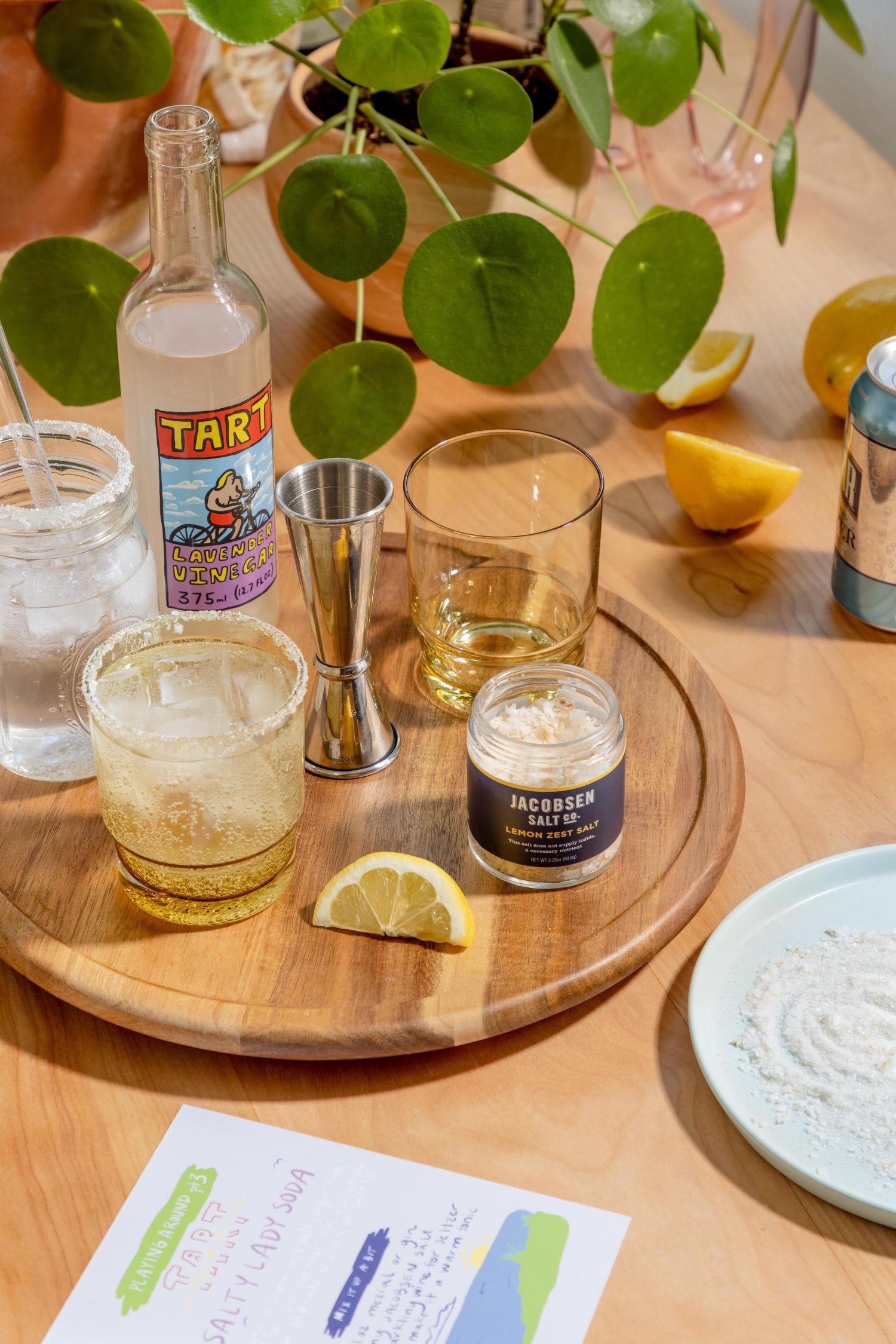 A table with vinegar, salt, and assorted glassware for making soda.