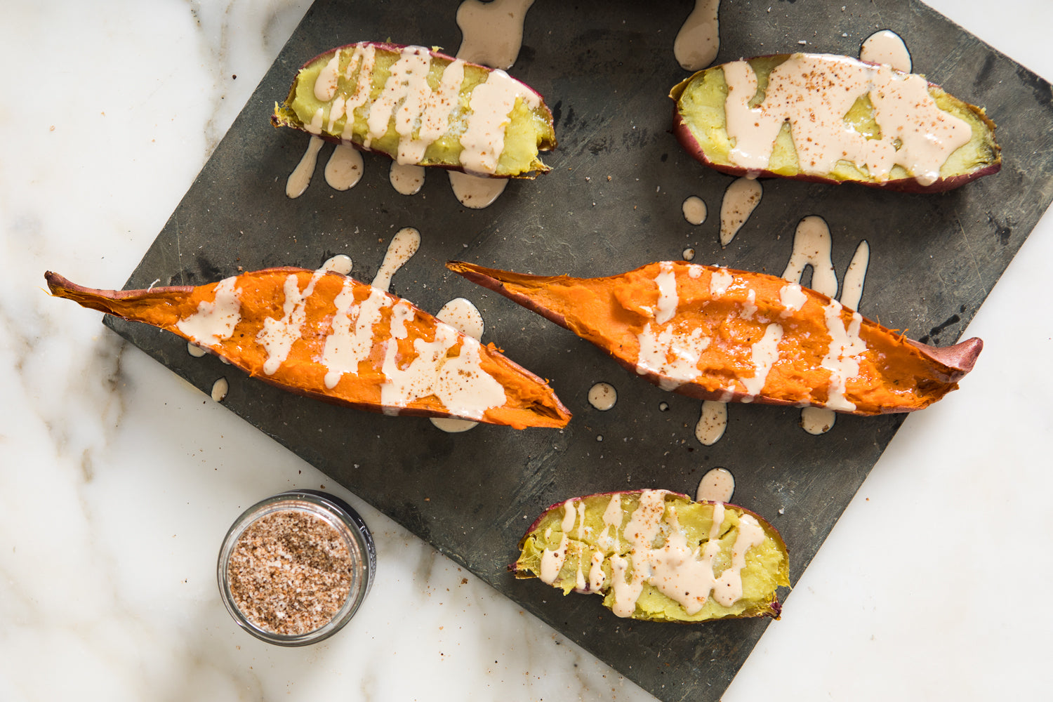 Sweet potatoes with drizzles of tahini dressing.
