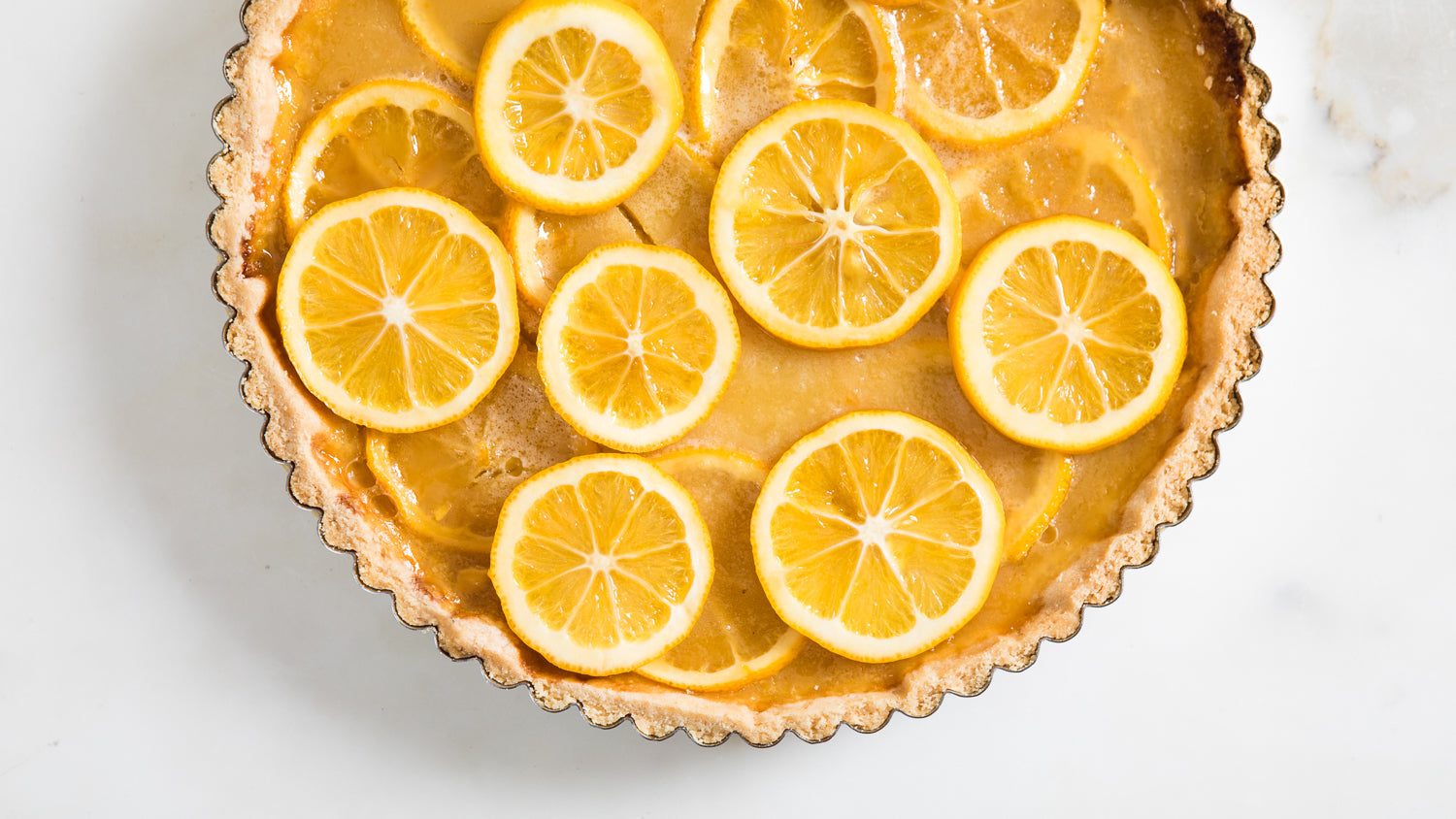 A lemon tart with slices of lemon on top.