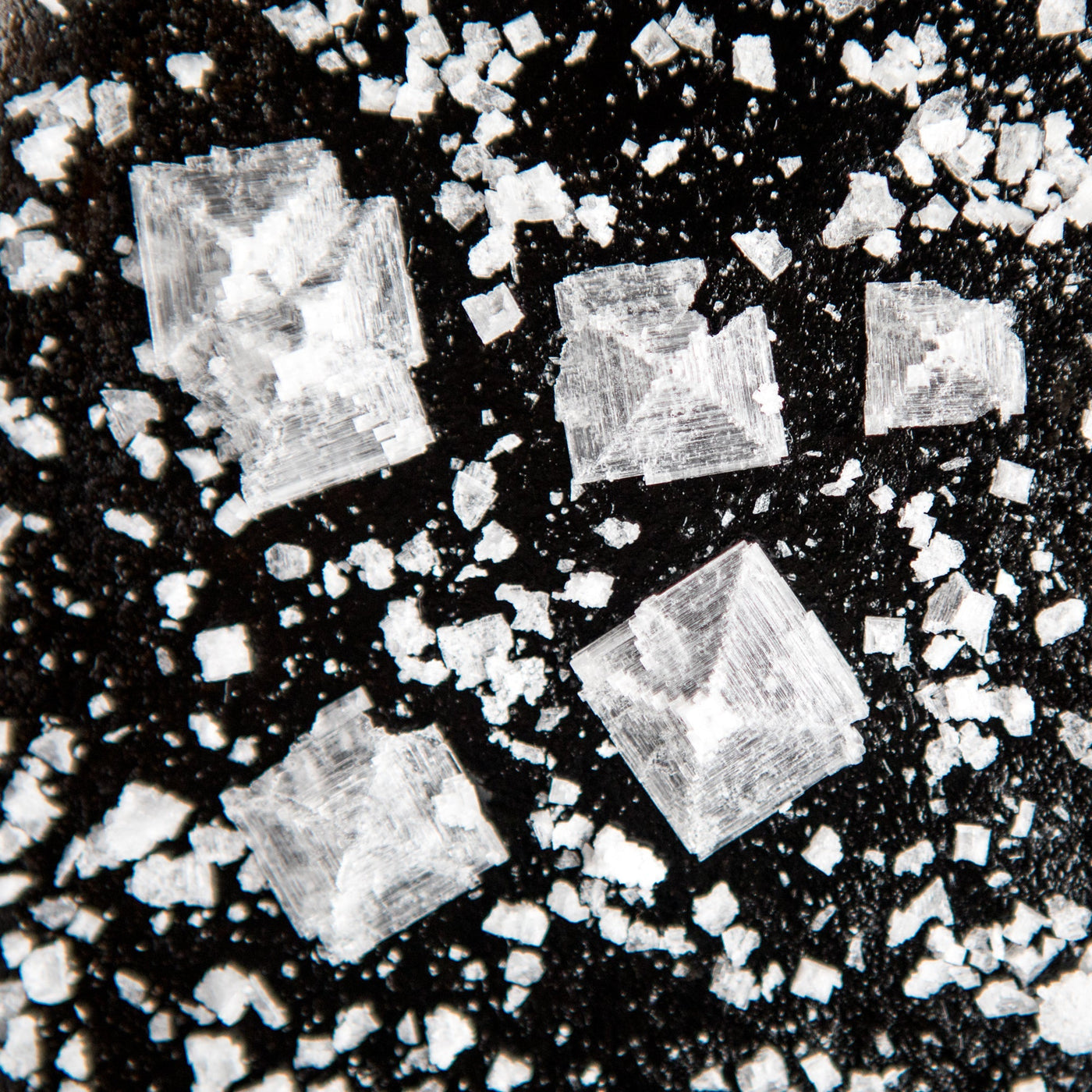 A close-up shot of salt crystals on a black background.