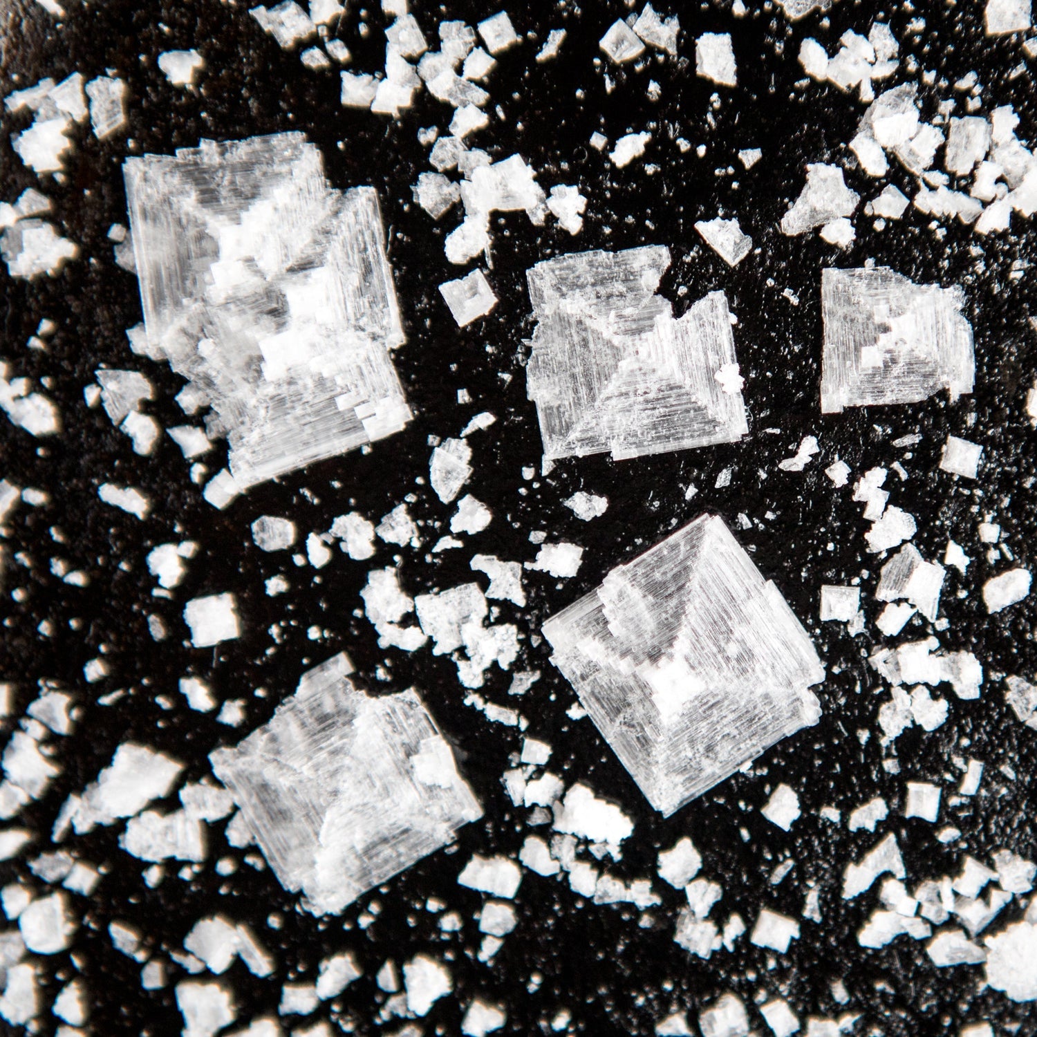 A close-up shot of salt crystals on a black background.