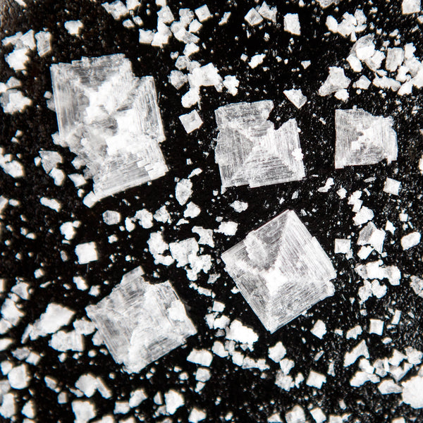 A close-up shot of salt crystals on a black background.