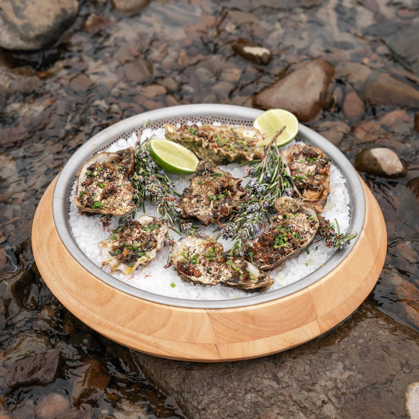 A a plate of oysters on ice with lime slices.