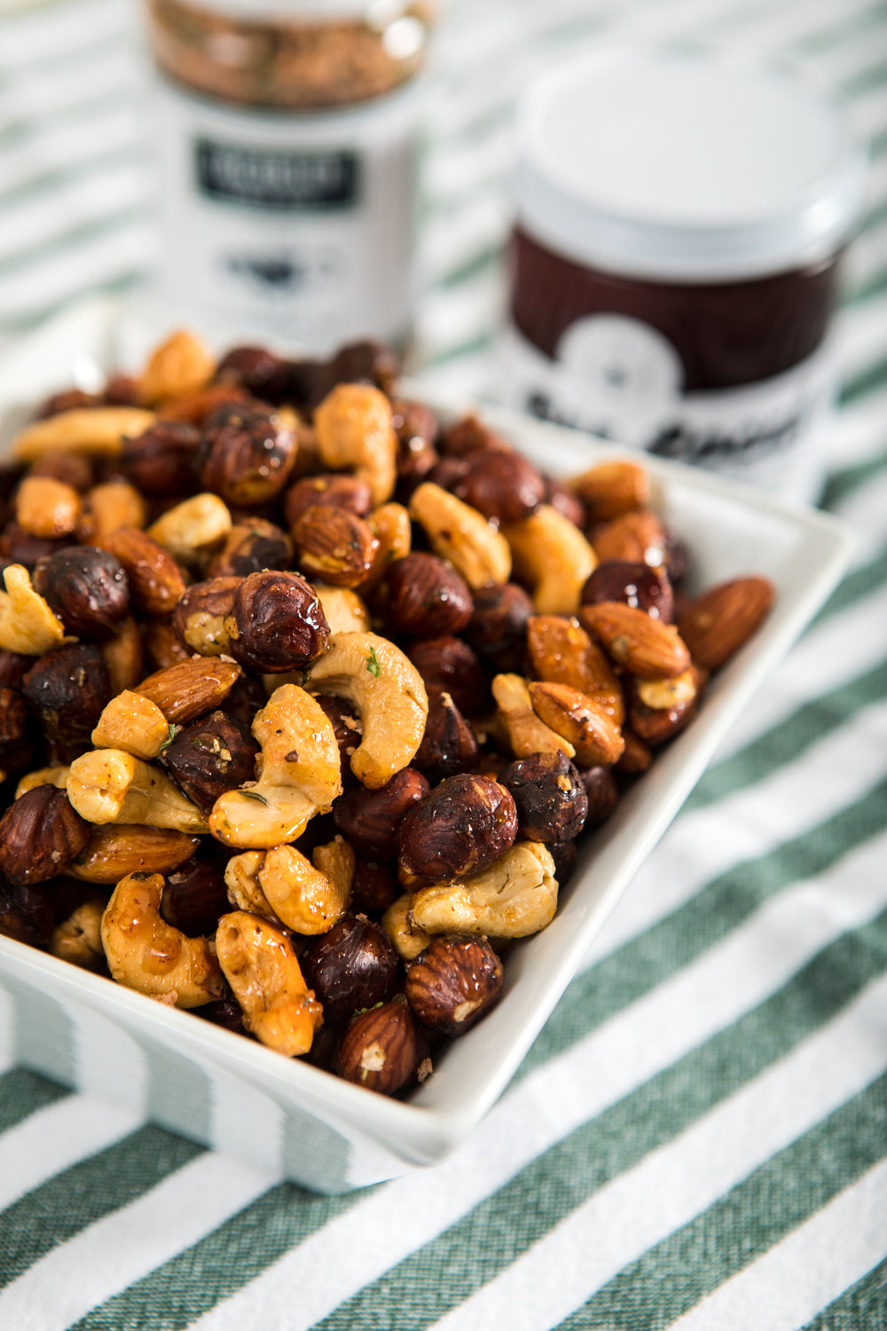 A bowl of nuts mixed with honey and steak seasoning.