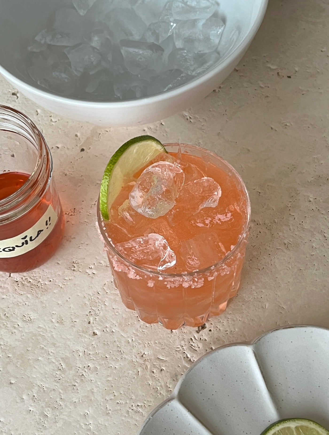 Iced pink beverage, garnished with a slice of lime.