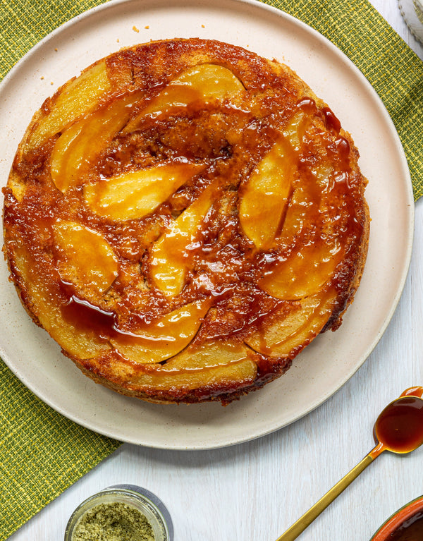 Orange cake with visible slices of pear baked in, topped with caramel sauce.
