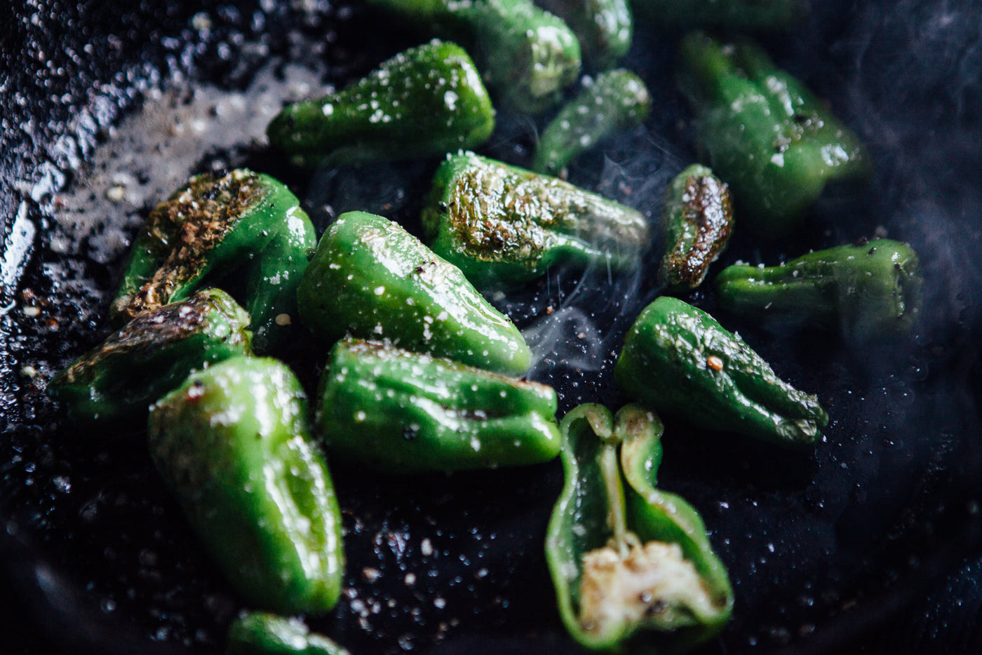 Close up of seasoned green peppers in a skillet