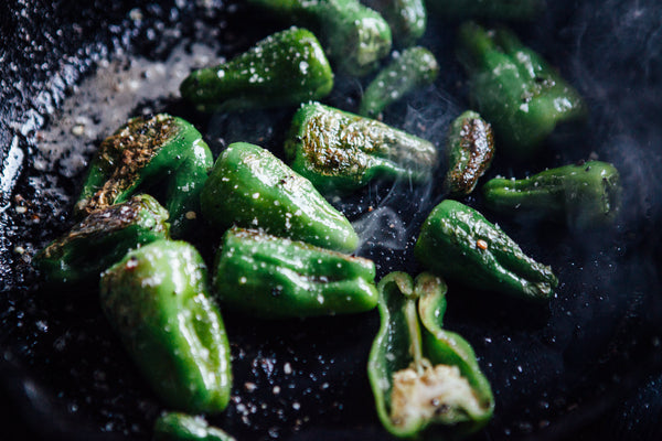 Close up of seasoned green peppers in a skillet