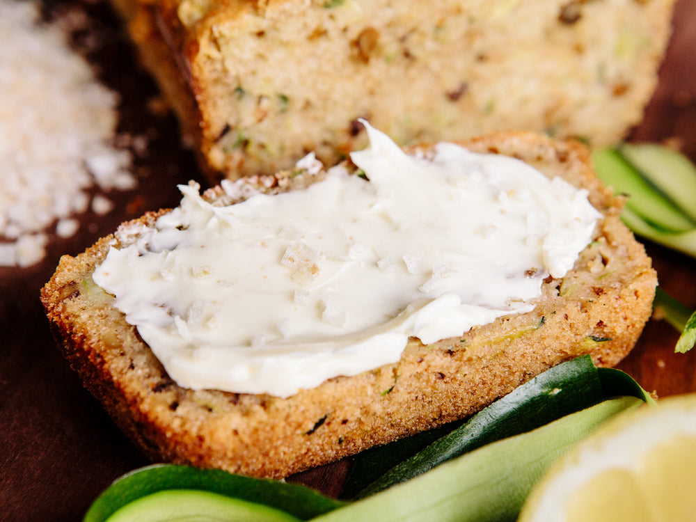 Closeup of zucchini bread topped with butter and Lemon Zest Salt