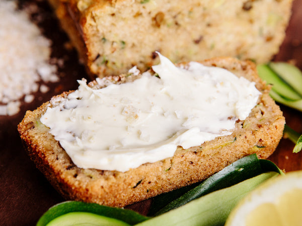 Closeup of zucchini bread topped with butter and Lemon Zest Salt