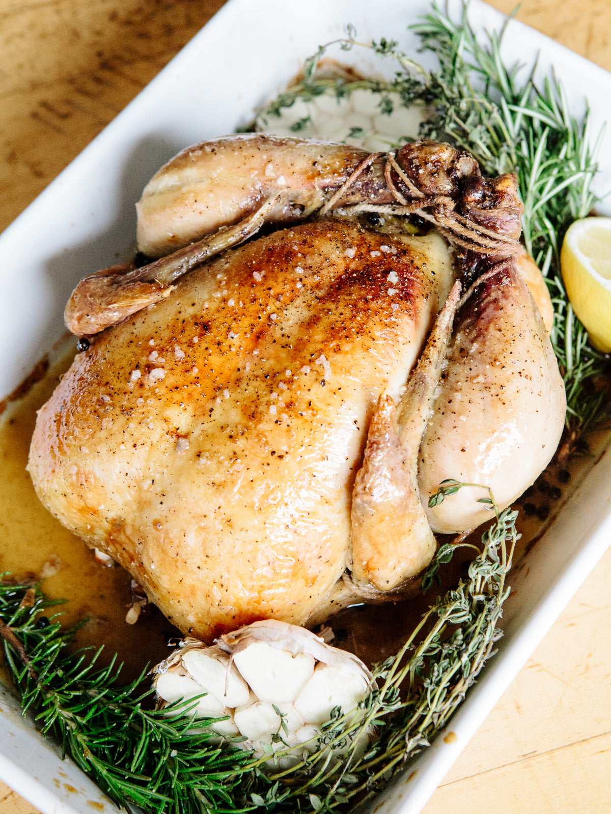 Overhead shot of roasted chicken, surrounded with greens