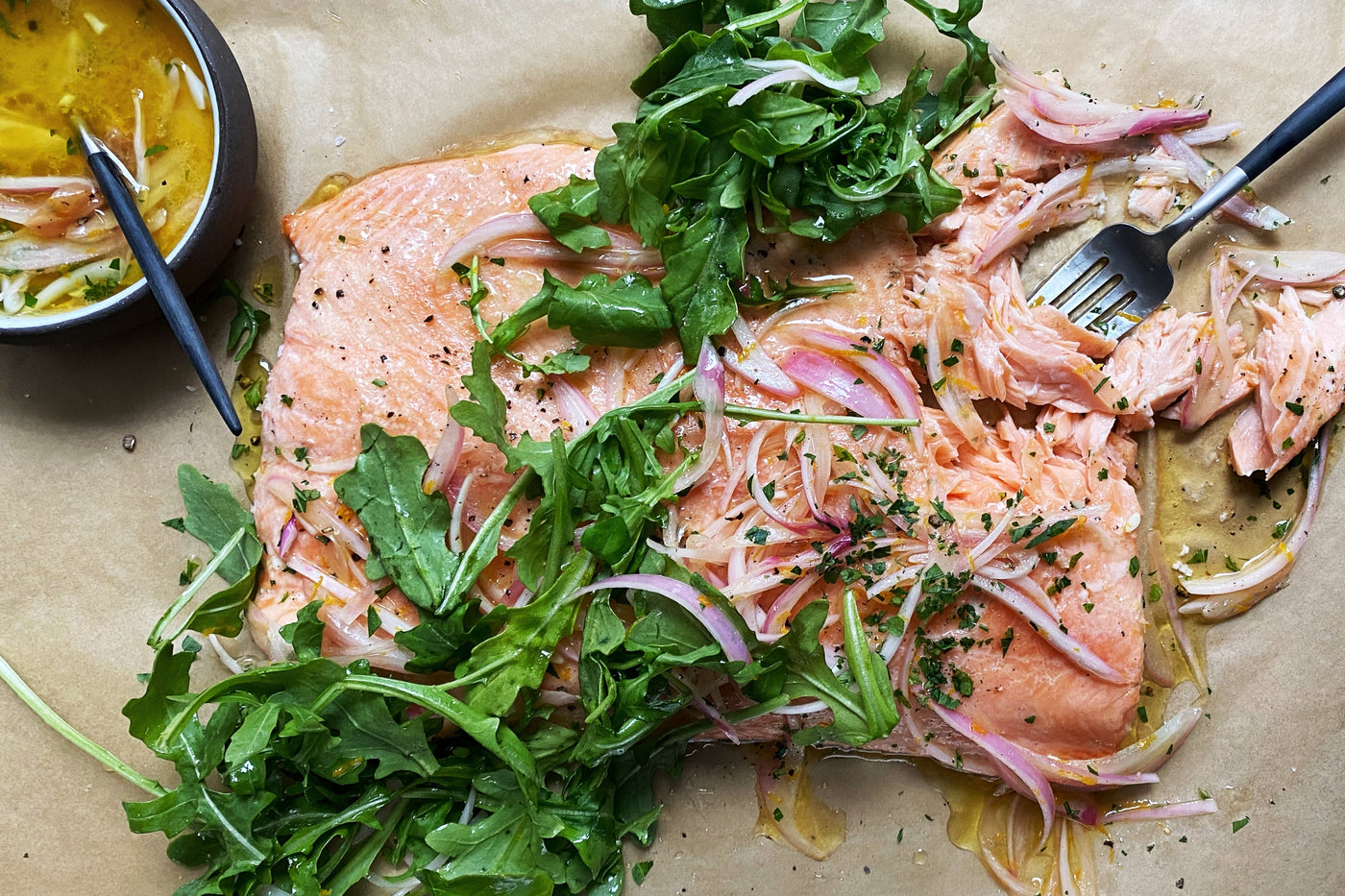 Roasted salmon and arugula on a piece of parchment paper.