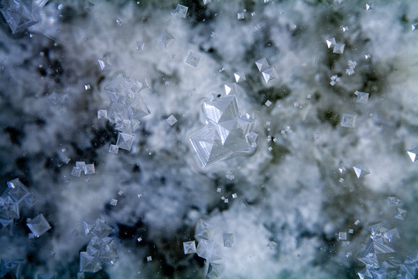Large, pyramid esque salt crystals floating in the water.