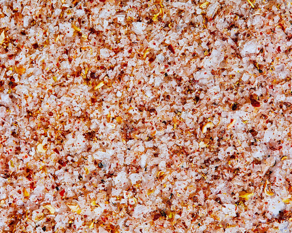 A close-up photo of tingly Sichuan sea salt. There are visible flakes of dry peppers and granules of salt.