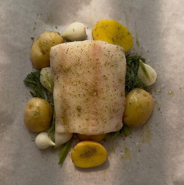 Seasoned Black Cod on a bed of potatoes, garlic and rosemary.