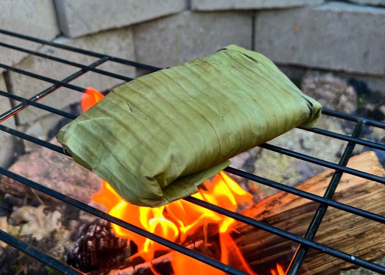 Banana leaves roasting over an open fire.