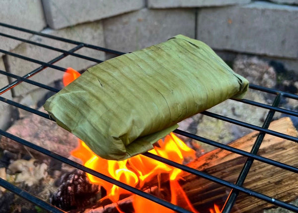 Banana leaves roasting over an open fire.