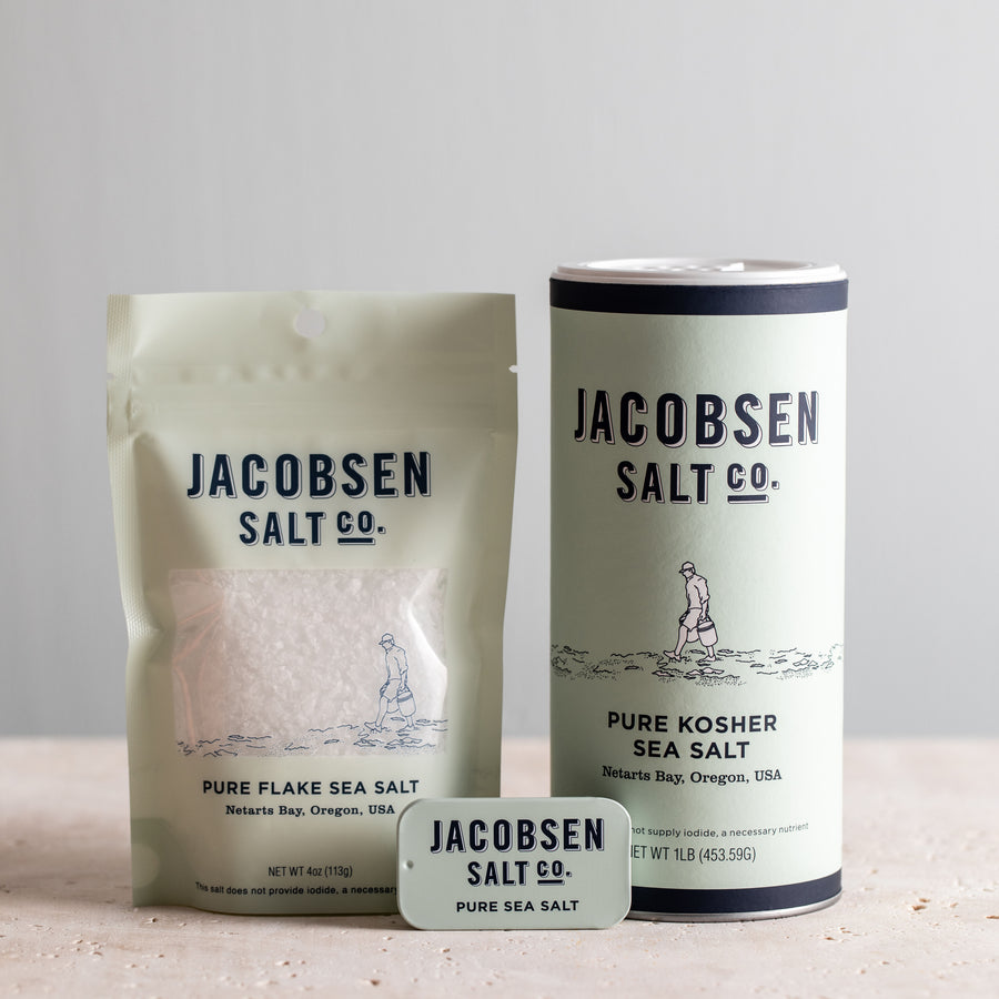 Jacobsen Salt Co. bundle of pure Oreogn salt products, including a bag of Pure Flake Sea Salt, a Pure Kosher Sea Salt canister, and a Pure Sea Salt slide tin.