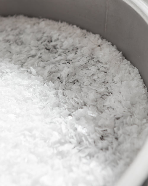 A large pile of flake salt in a grey bowl. 