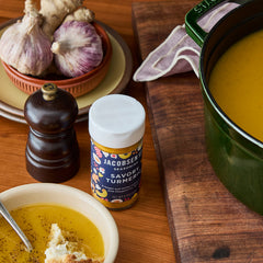 Jacobsen Savory Turmeric jar next to turmeric soup on a set tablescape.